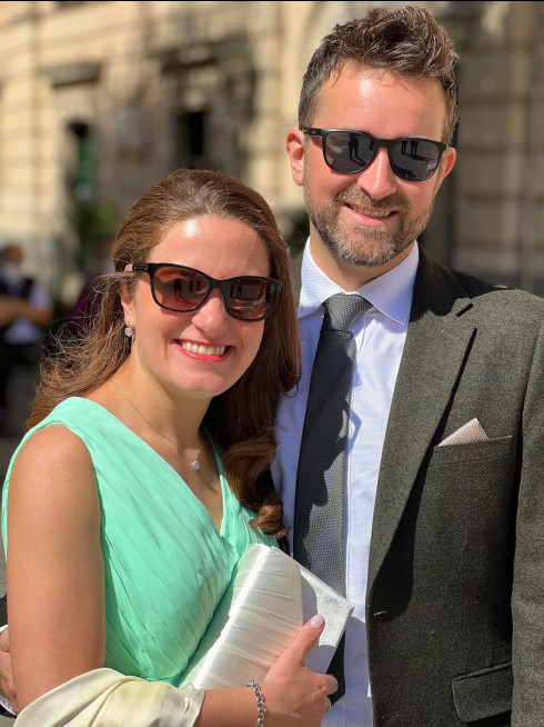 Jay and Filly outside the church at their civil ceremony, dressed smart and smiling with sunglasses on.