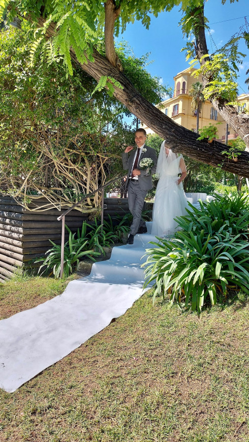 Giulio walking Filly down the aisle, with a white carpet.