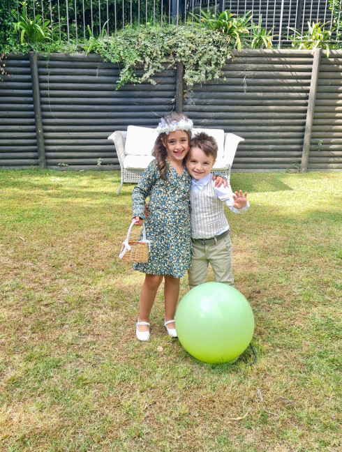 Chiara and Sergio in front of a green inflatable ball in the venue garden.