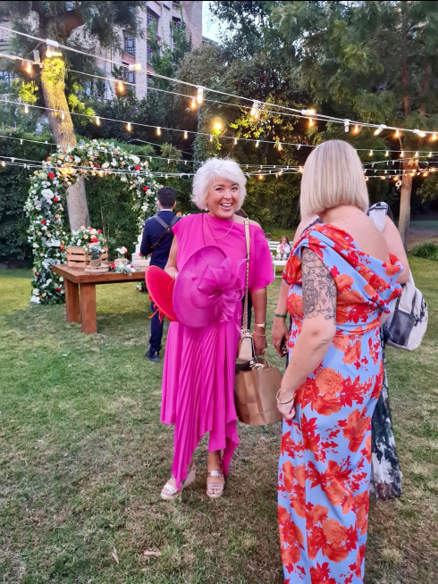 Vicky and Addy, Jay’s mum and sister, in the venue grounds, holding their hats and laughing.