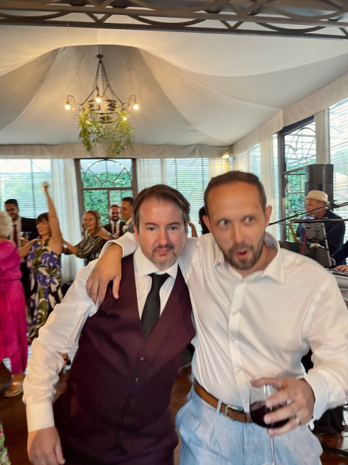 Martin and Dave, Dave joking with his arm around Martin holding a glass of red wine.