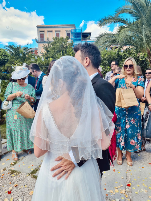 Jay and Filly in front of a crowd throwing confetti after getting married.