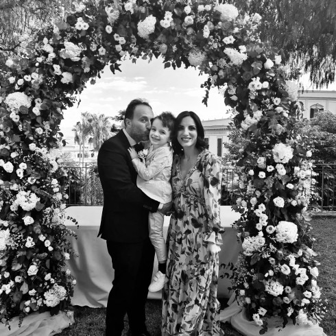 Renato, Sergio, Fernanda in front of the wedding arch.