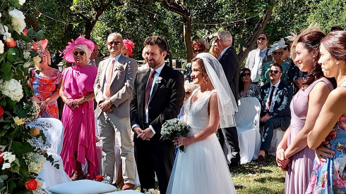 Jay and Filly at the front of the wedding arch, smiling and waiting for the ceremony to begin.