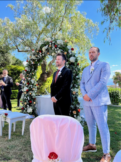 Jay and Dave waiting at the wedding arch.