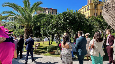 Guests stand in the garden with the photographer wandering through them.