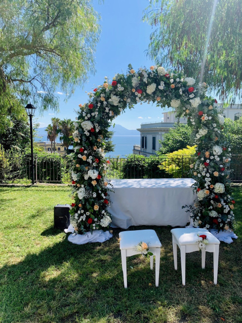 The wedding arch before the ceremony with two empty chairs in front of it.