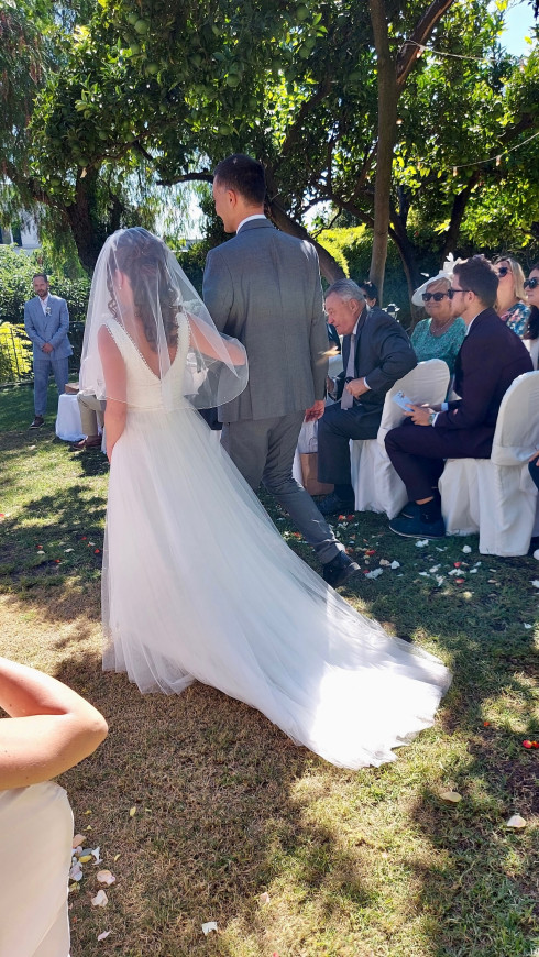 Giulio walking Filly down the aisle while guests look from the right.
