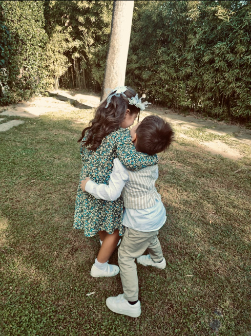 Chiara and Sergio play-wrestle in the garden.
