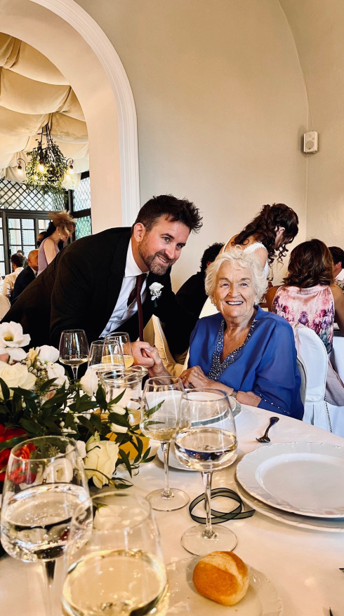 Jay leaning down at the table with Grandma.