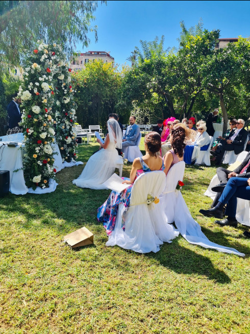 Filly reads to Jay during the service at the front of the flower arch.