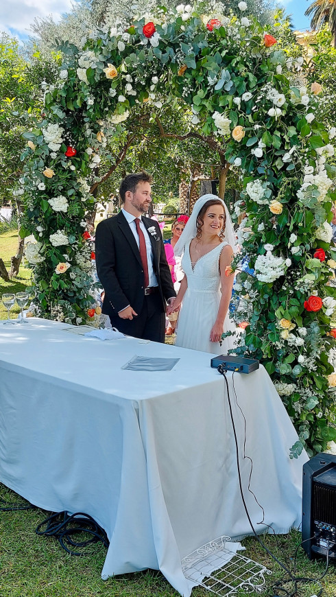 Jay and Filly holding hands in front of the wedding arch.