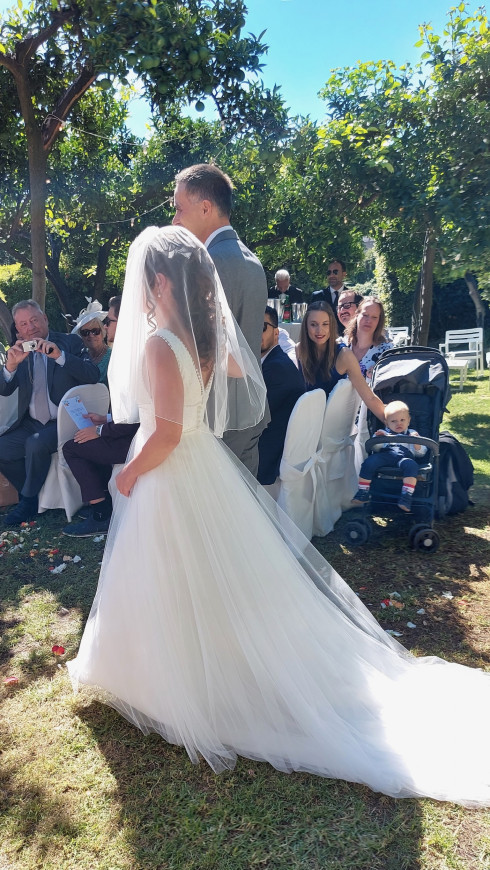 Giulio walking Filly down the aisle. Guests behind including Valentino in the pram.