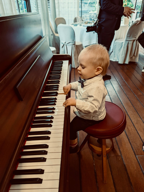 Baby Valentino sat on the piano pressing the keys.