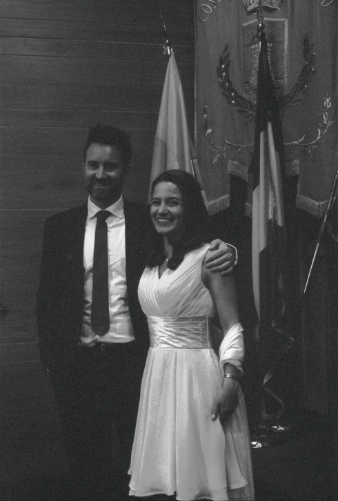 Jay and Filly, just after the civil ceremony, standing in the county hall in front of a Marigliano flag.