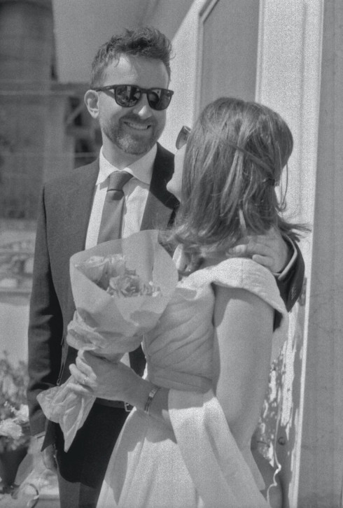 Close up of Jay and Filly on the steps of Filly's family house in Marigliano, with Filly holding some flowers.