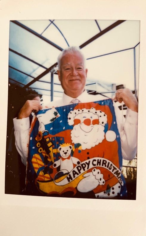 Polaroid of uncle Dave holding up a Santa sack.
