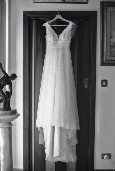 Filly's wedding dress hanging up on the door at home.