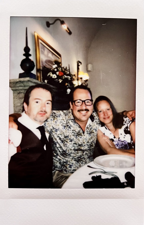 Martin, Rob, and Jannie at the table. Rob is in the middle with his arms around both.